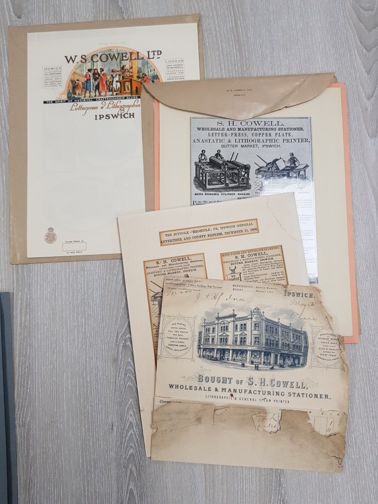 A photograph of letterheaded paper used by W.S Cowell Ltd, alongside press adverts and other business paperwork.