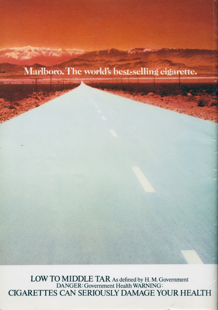 An advert of a road leading into red mountains, with the words: Marlboro. The world's best-selling cigarette. written across the image. At the bottom a public health warning.