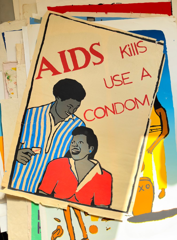 A poster of two people with the text: Aids kiss Use A condom.